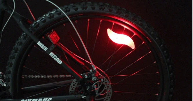 LED bicycle spoke lights in various colors mounted on bike wheel for night safety