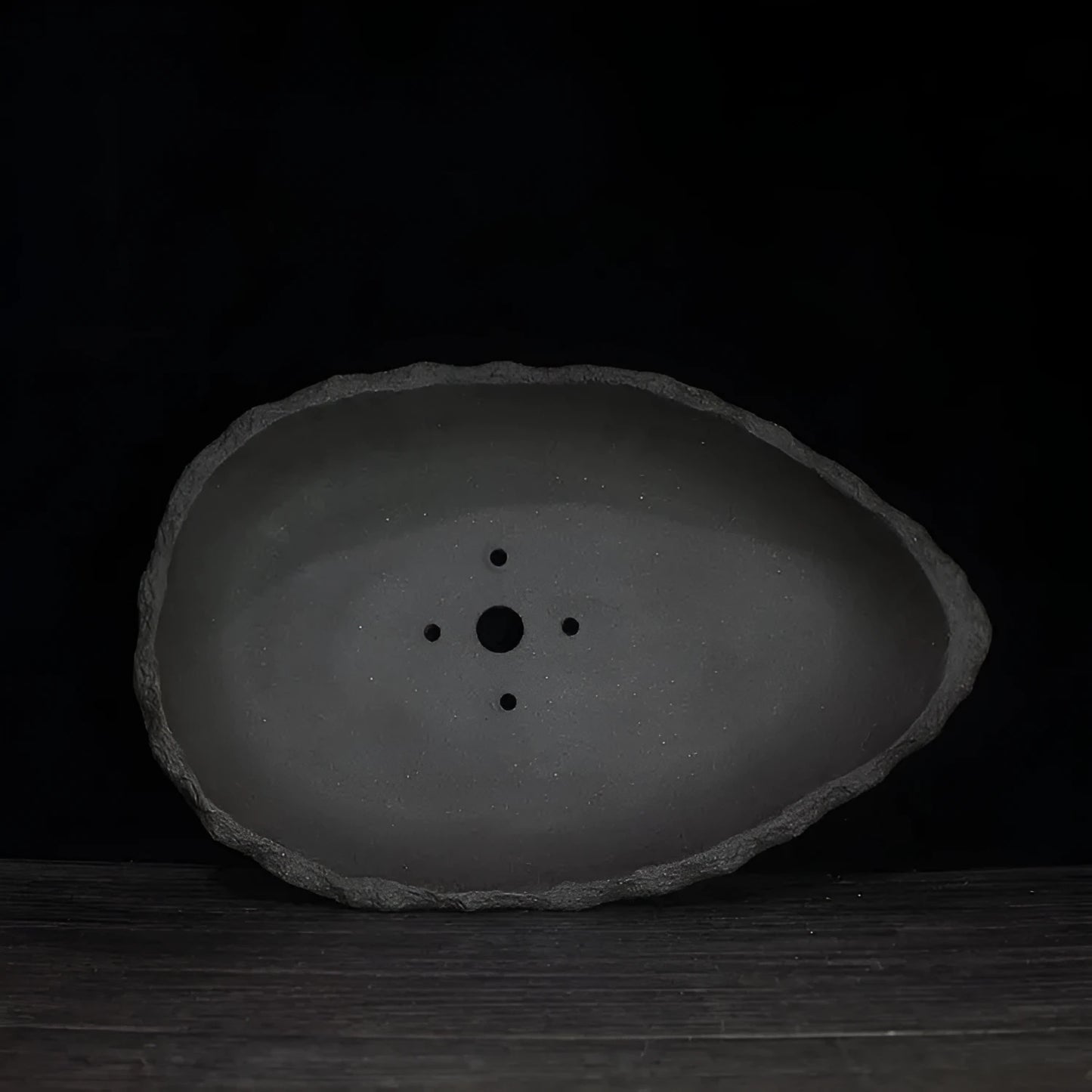 Handmade purple clay flower pot with unique shape showing natural ceramic texture