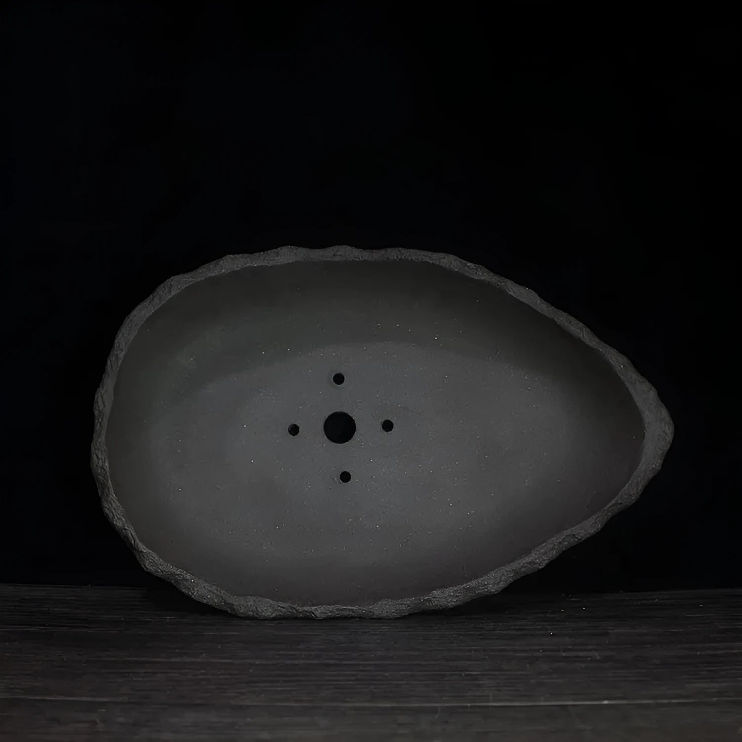 Handmade purple clay flower pot with unique shape showing natural ceramic texture
