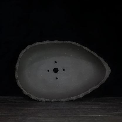 Handmade purple clay flower pot with unique shape showing natural ceramic texture