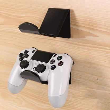 A universal black game controller mounting bracket shown installed on a wall.