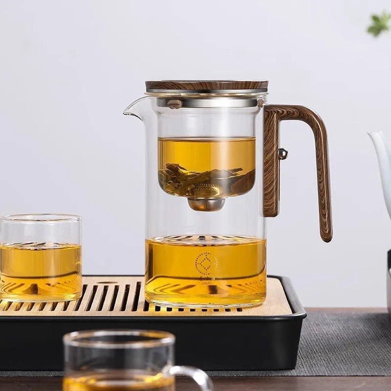 Elegant glass tea infuser pot with magnetic separation technology, wooden handle, and precise pouring spout