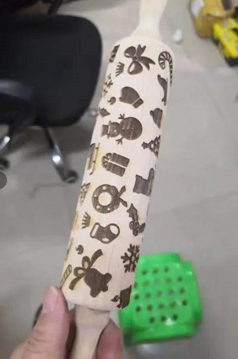 Wooden rolling pin with engraved Christmas patterns including reindeer and snowflakes on a 45cm long barrel.