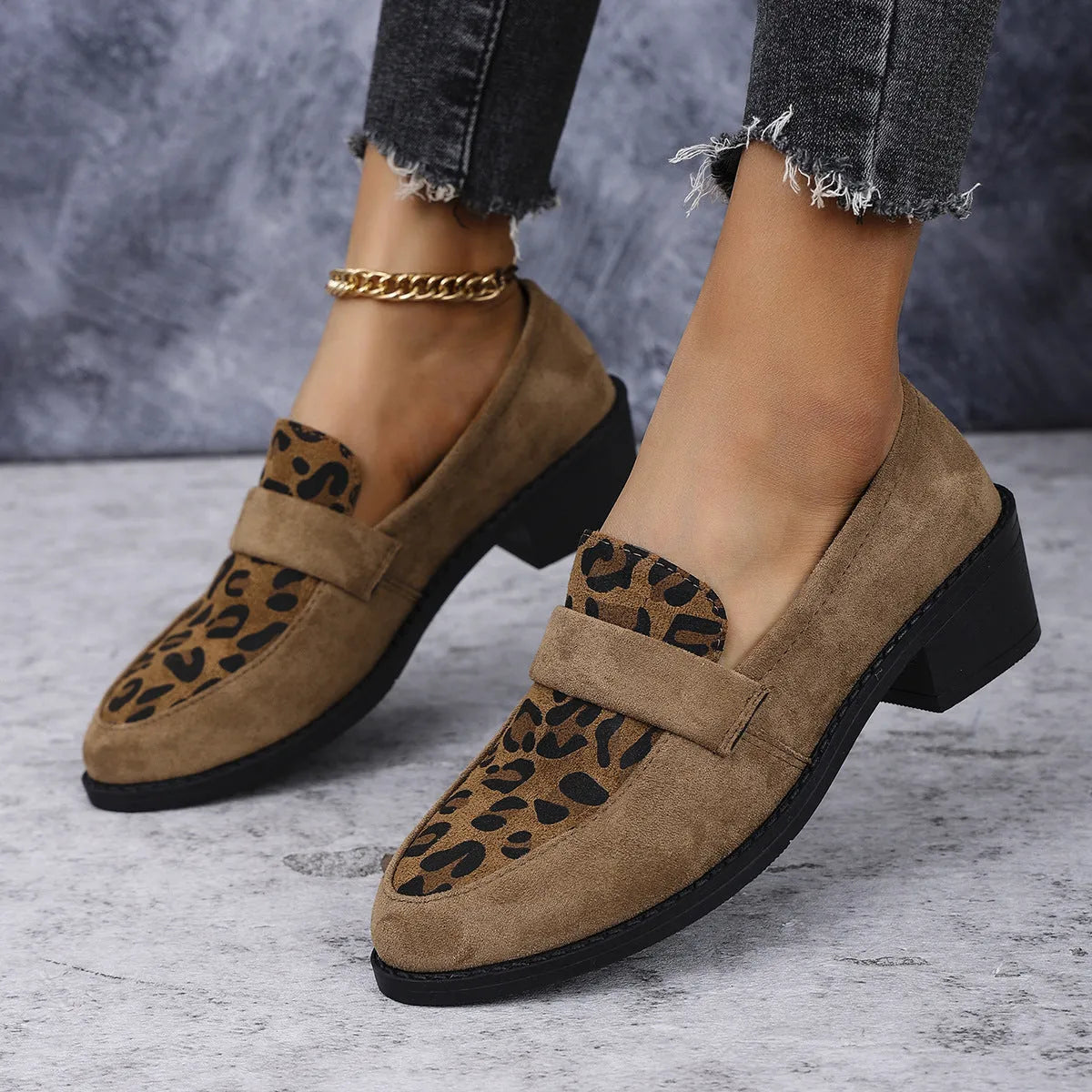 Leopard print slip-on suede pump shoe with chunky mid heel and pointed toe on a rubber sole.