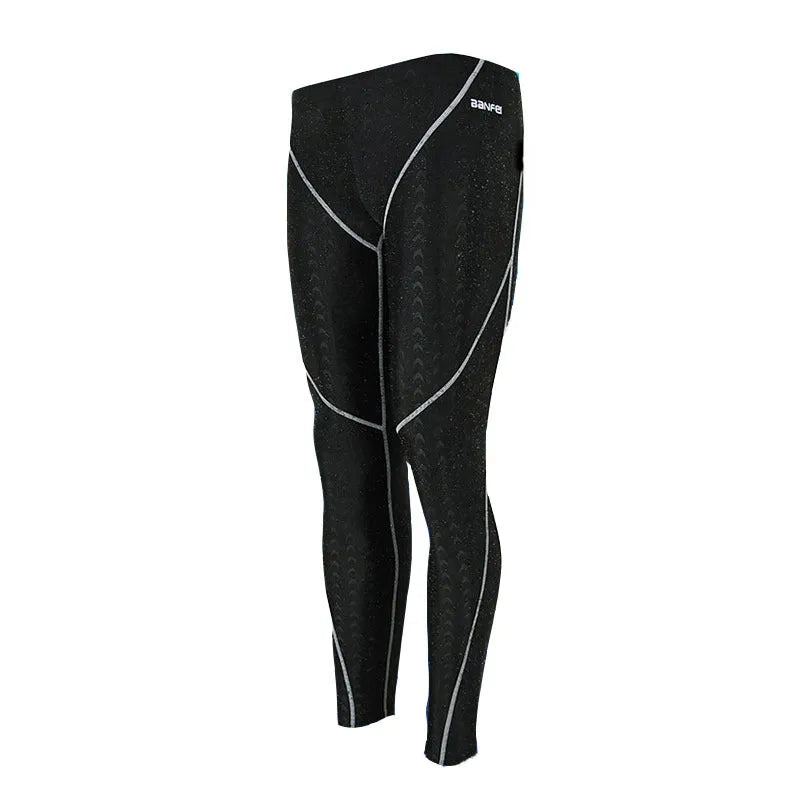 Men's black and grey cropped nylon swimming trunks with mesh lining, laid flat.