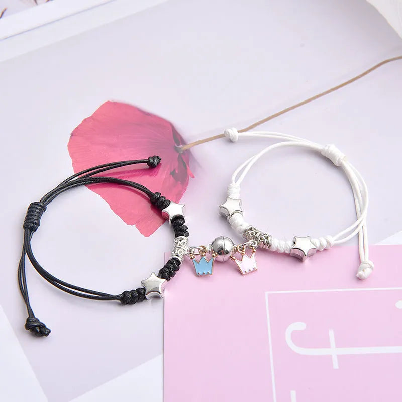 Magnetic suction couple bracelet pair in alloy with an electroplated finish, showing example designs like a crown and love lock.