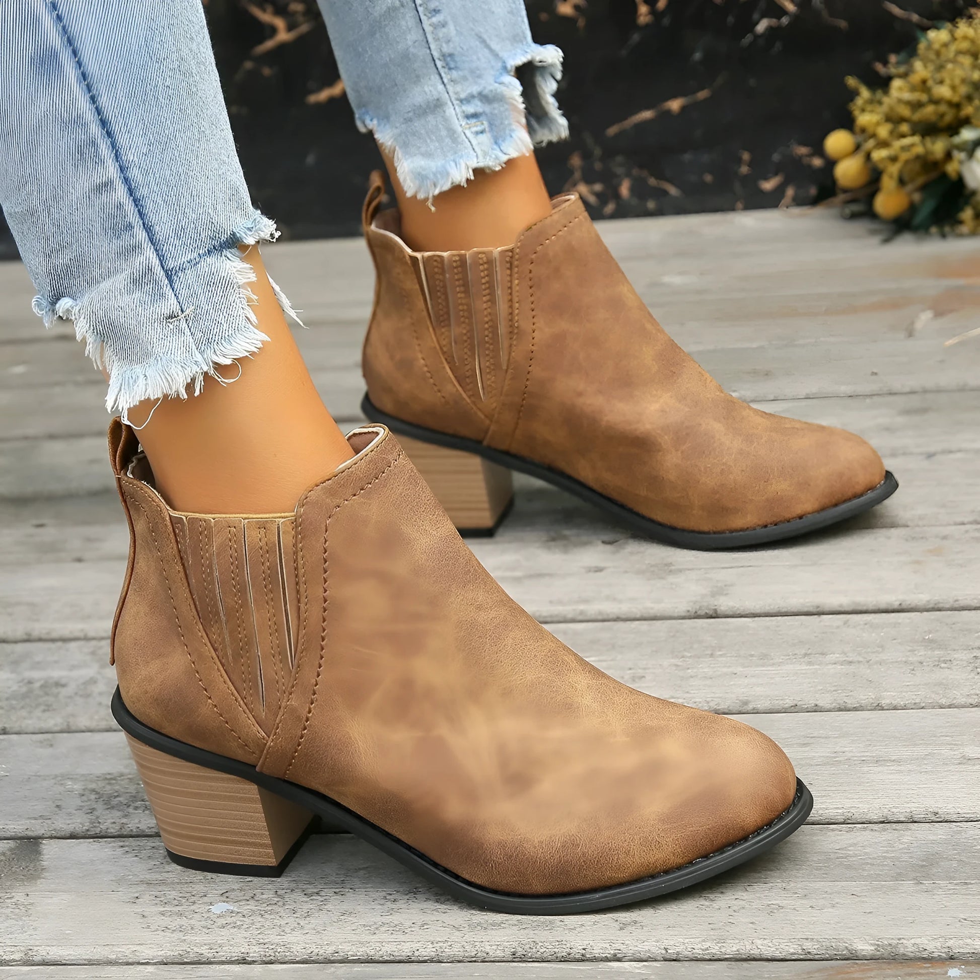 Black and brown women's ankle boots with a pointed toe and thick square low heel, slip-on design.