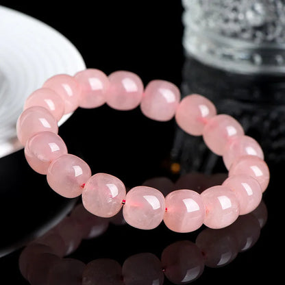Natural crystal barrel shaped bead bracelet with 19 pink 8-10mm polished crystal beads in geometric pattern