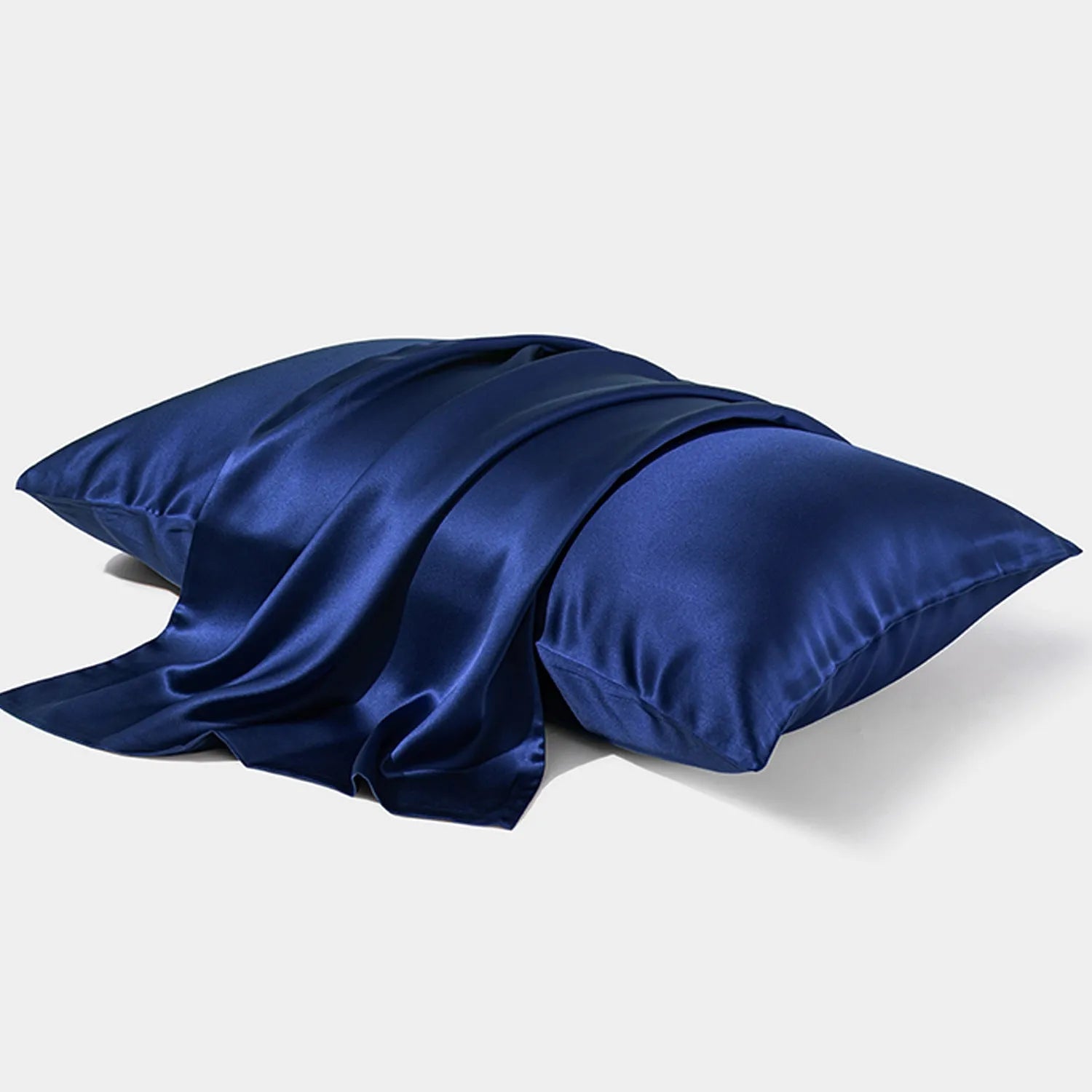 Dark grey silk pillowcase with envelope closure on a bed.