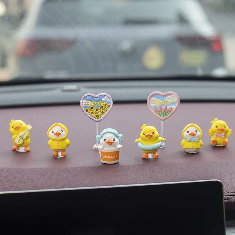 Set of six small yellow PVC ducklings and a white Hello sign for car dashboard decoration.