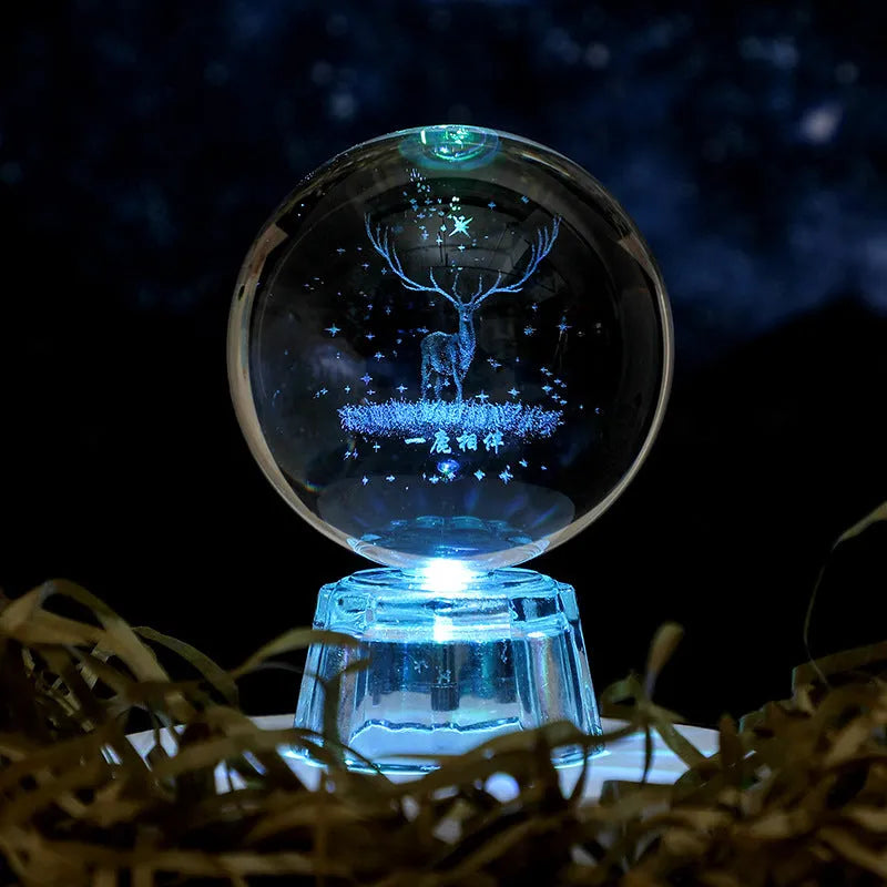 Transparent crystal ball ornament with inner carving of clouds, shown on a wooden table.