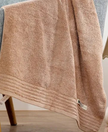 Beige and brown cotton towel set showing bath, hand, and face towel sizes.