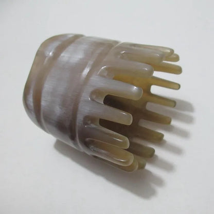 Black half-moon shaped buffalo horn comb with wide teeth for scalp massage and detangling hair.