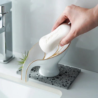 Elegant ceramic soap dish with leaf-shaped design, suction cup, and drainage holes for bathroom and kitchen use