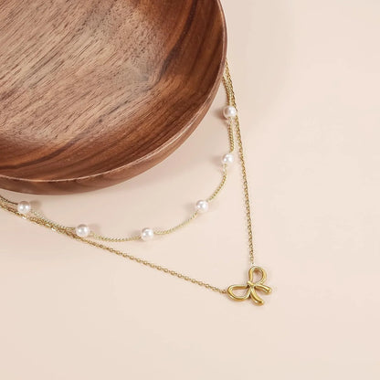 Double layer pearl choker with bow pendant in gold and silver options