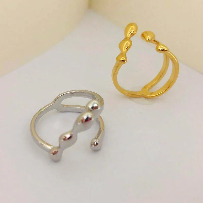 Gold and silver adjustable brass ring featuring a large spherical design on an open shank.