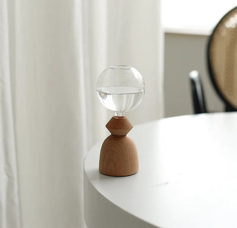 Geometric clear glass bubble vase on wooden base showing conical and arc bottom style options