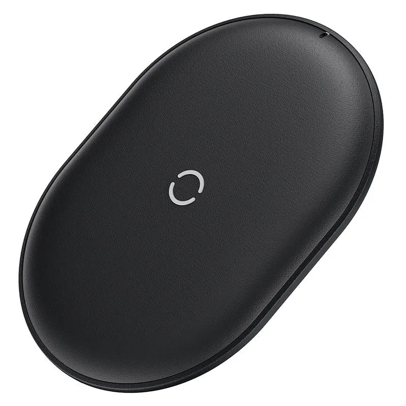 Baseus Rough 15W wireless charging pad in black on a wooden desk next to a smartphone.