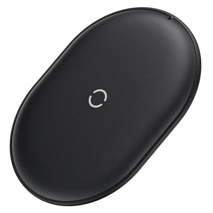 Baseus Rough 15W wireless charging pad in black on a wooden desk next to a smartphone.