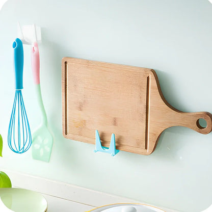 Blue plastic kitchen organiser mounted inside cabinet door holding spatula and spoon
