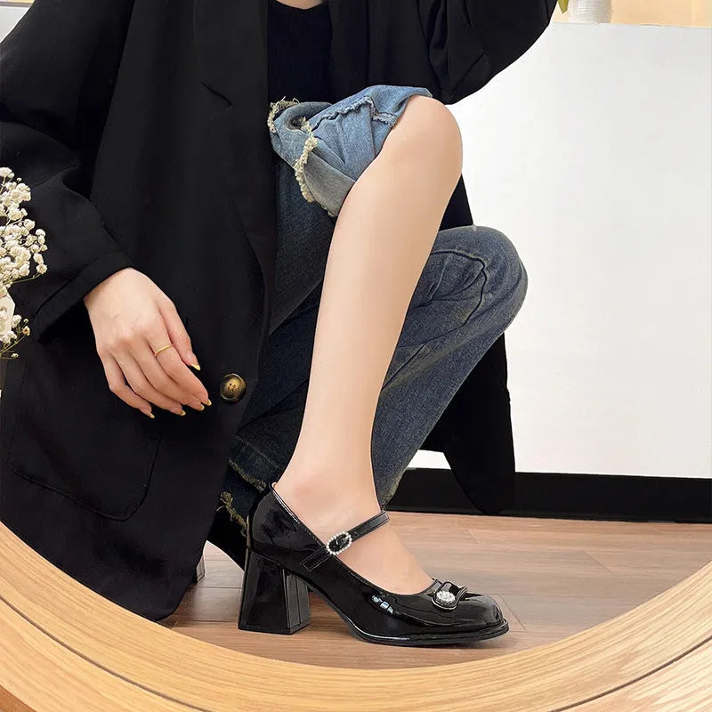 Women's black patent leather wide fit high heels with a round toe and chunky block heel.