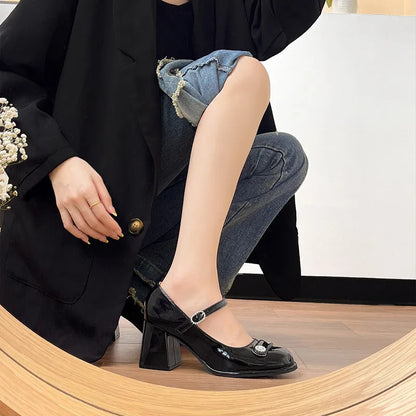 Women's black patent leather wide fit high heels with a round toe and chunky block heel.