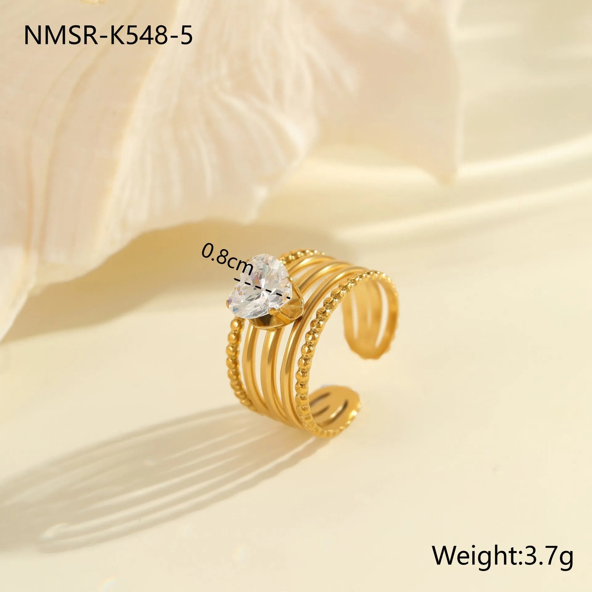 Gold electroplated stainless steel open mouth ring with geometric shapes and zircon inlay on a heart drop.