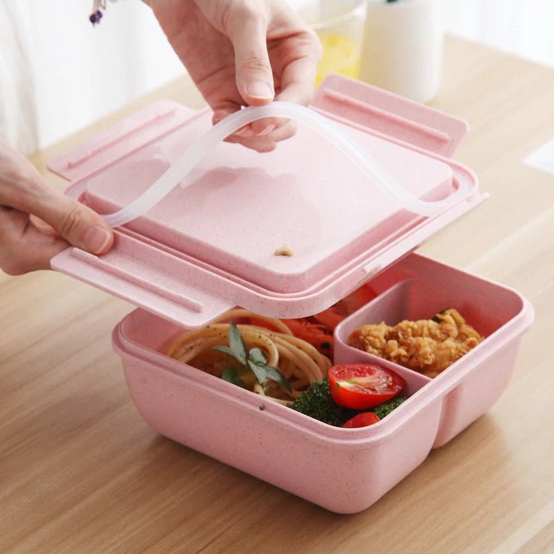 Japanese-style microwave-separated bento box in pink, green, and beige with spoon and chopsticks