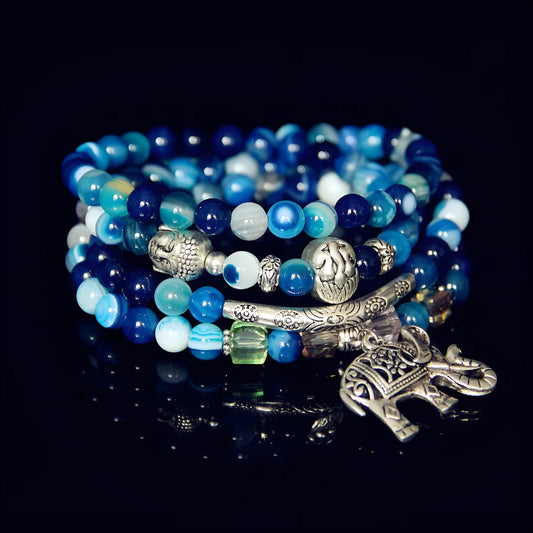 Multi-layer agate amulet bracelet with 6mm beads in blue elephant pattern on a wrist.