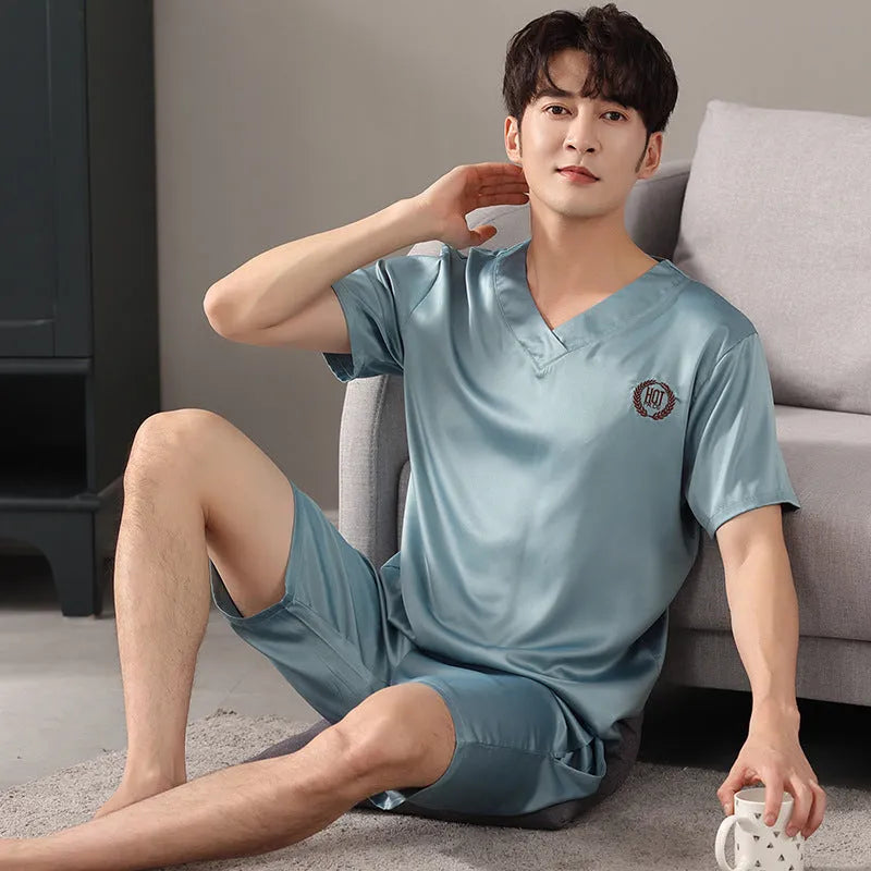 Man wearing a loose fit light blue ice silk short-sleeve pajama shirt and matching shorts.