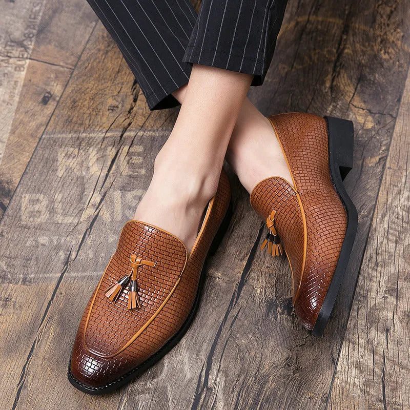 Men's black pointed toe slip on shoe with a decorative tassel on the artificial PU upper.