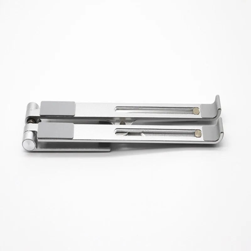 Black and silver aluminum laptop stand measuring 26cm wide on a wooden desk.