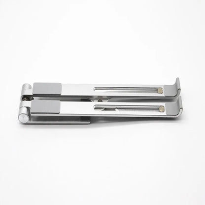 Black and silver aluminum laptop stand measuring 26cm wide on a wooden desk.