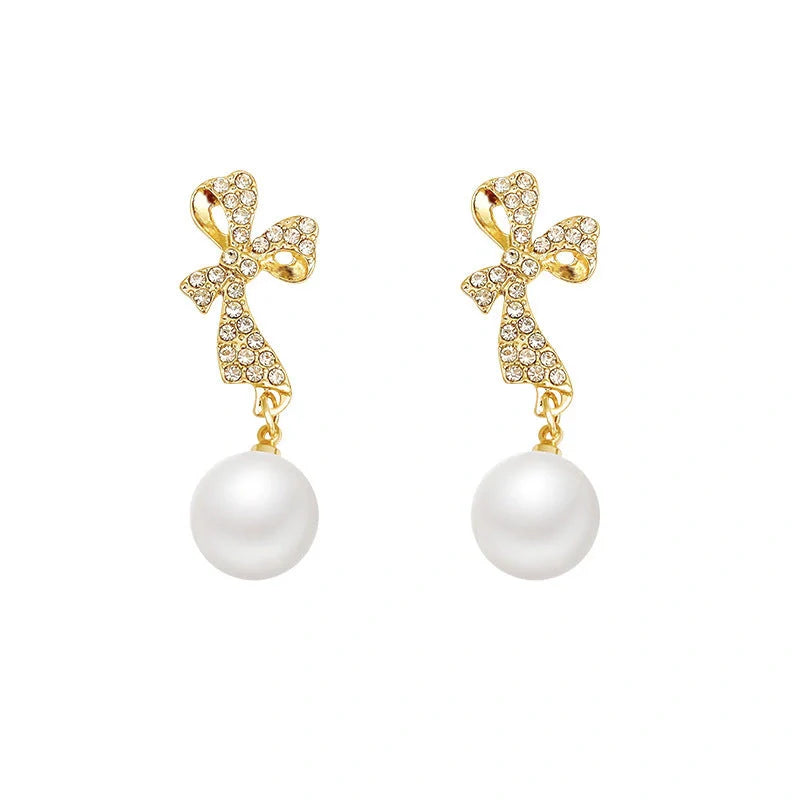 Gold bow-shaped earrings with crystal embellishments, lightweight and elegant
