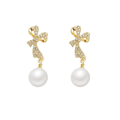Gold bow-shaped earrings with crystal embellishments, lightweight and elegant