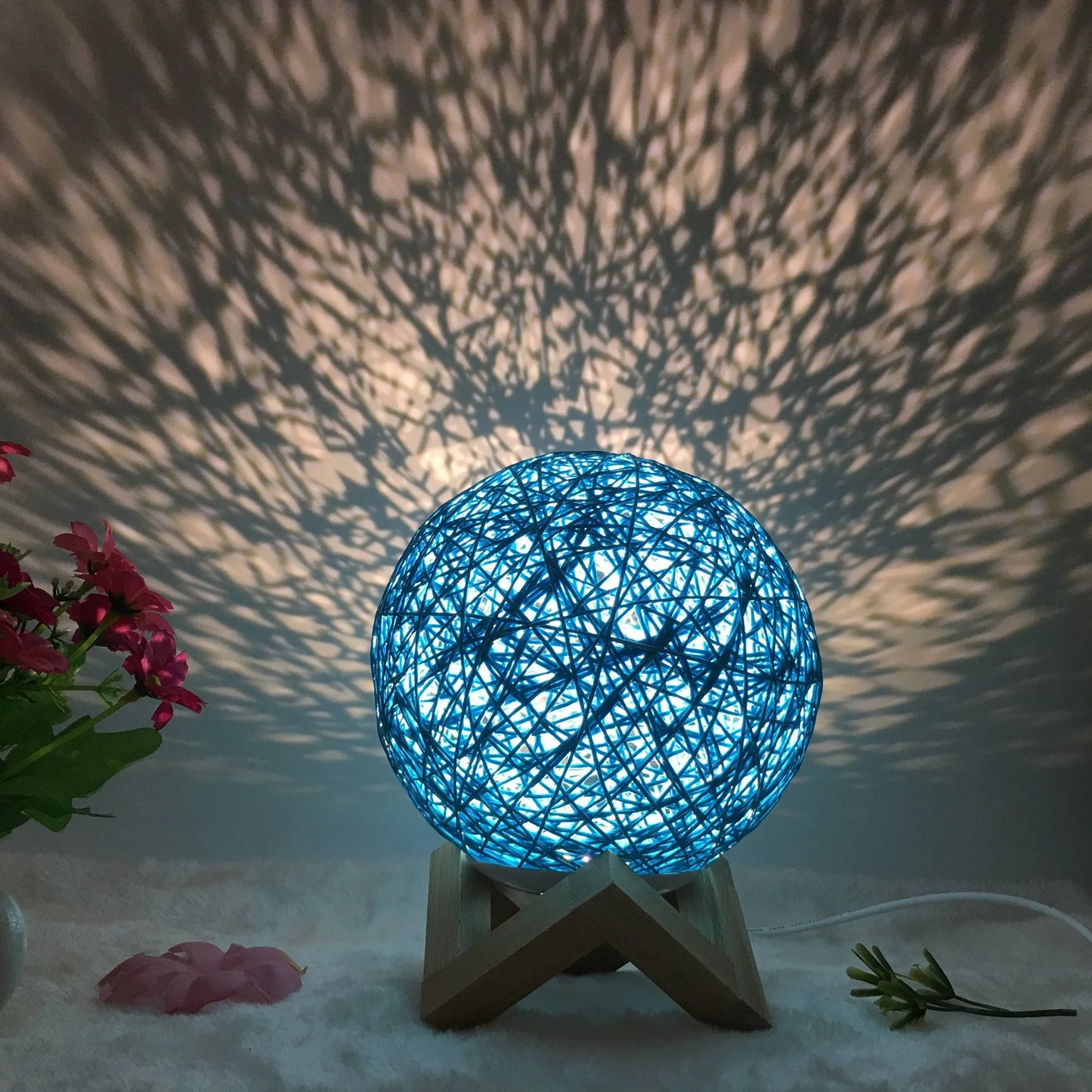 Spherical hand-knitted rattan table lamp with remote control on a wooden desk