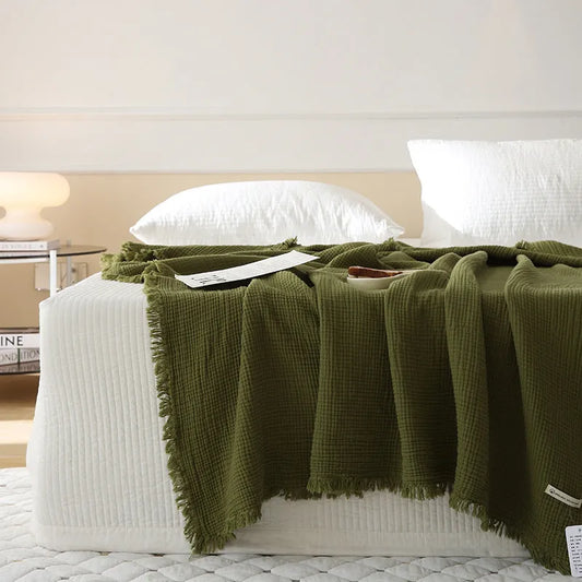 Four-layer gauze tassel blanket in cotton, showing tassel edges and textured fabric, available in multiple colours and sizes