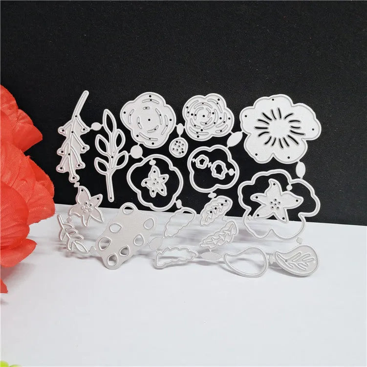Silver carbon steel flower paper cutting mould measuring 14.3 by 9.9 cm with etched plant design