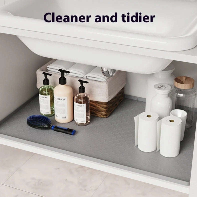 Grey silicone sink mat measuring 864mm by 558mm protecting kitchen cabinet from water damage