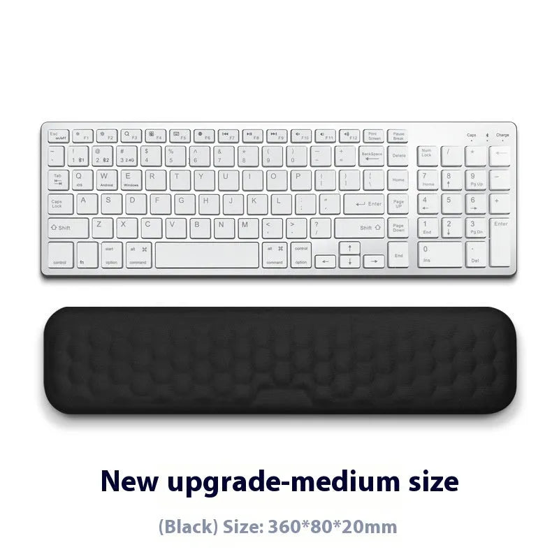 Black and grey memory foam mouse wrist rests with cloth and leather-style covers on a desk.