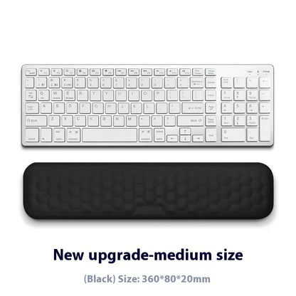 Black and grey memory foam mouse wrist rests with cloth and leather-style covers on a desk.