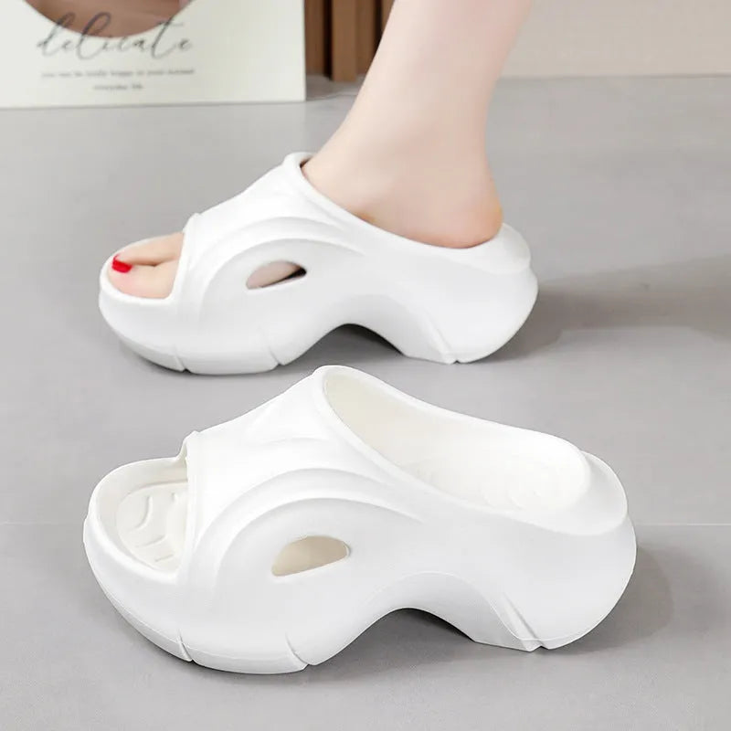 Women's thick-soled EVA foam beach slippers in rose red colour on a sandy background.