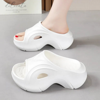 Women's thick-soled EVA foam beach slippers in rose red colour on a sandy background.