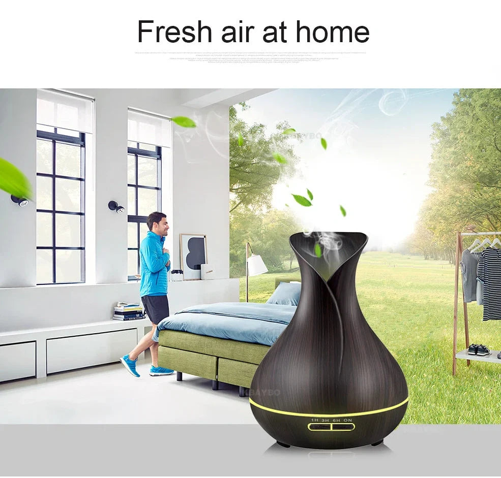 Black USB humidifier with colour-changing LED lights and water mist output, 15cm tall on wooden desk