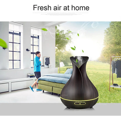 Black USB humidifier with colour-changing LED lights and water mist output, 15cm tall on wooden desk