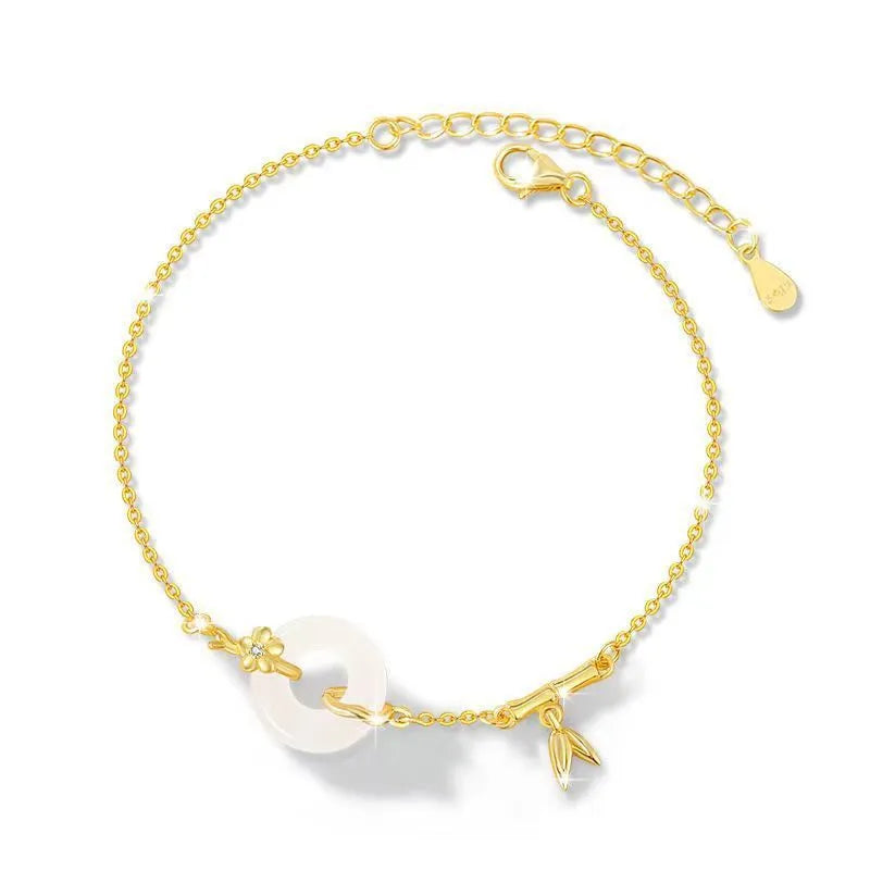 Gold-colour women's bracelet with peace symbol buckle and white chalcedony stone on silver band.