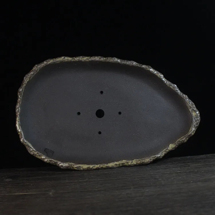Handmade purple clay flower pot with unique shape showing natural ceramic texture