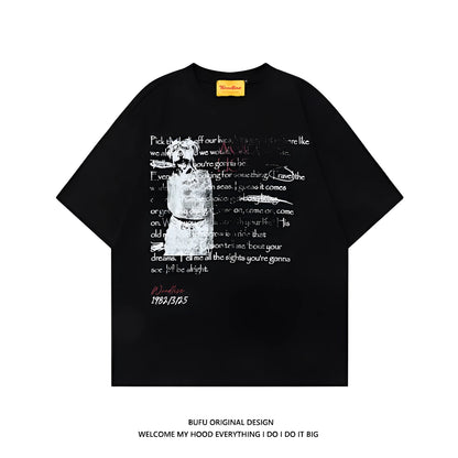 Man wearing a black loose-fit pure cotton t-shirt with a white letter print and short raglan sleeves.