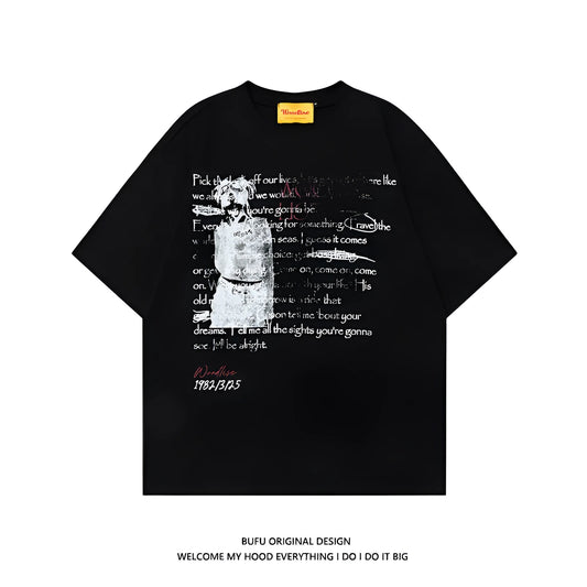 Man wearing a black loose-fit pure cotton t-shirt with a white letter print and short raglan sleeves.
