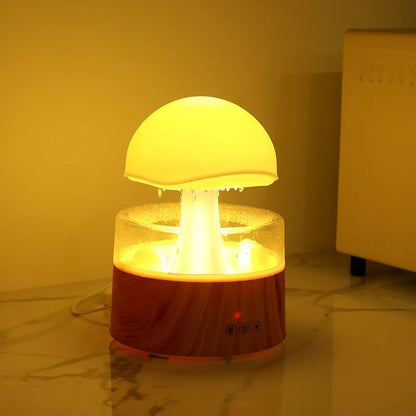 White rain cloud humidifier with falling water droplets and coloured LED lights on nightstand